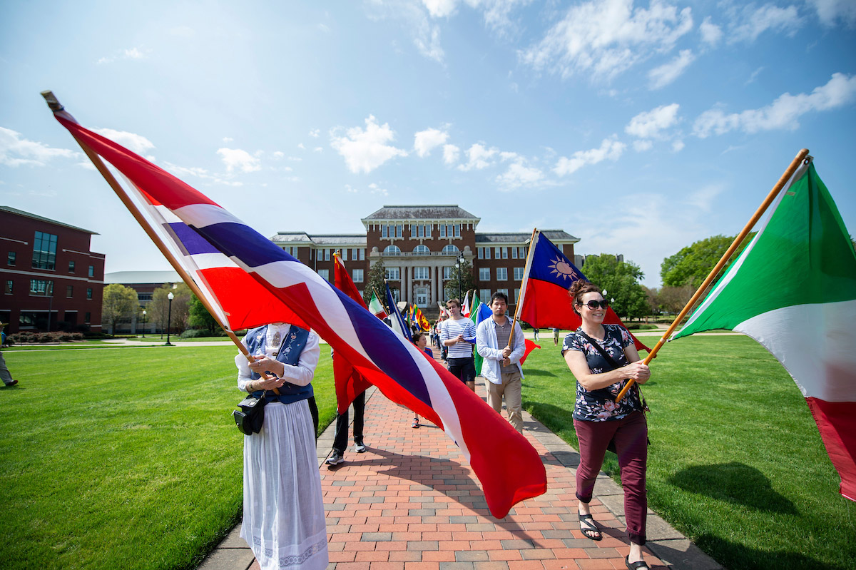Students waving international flags on the drill field