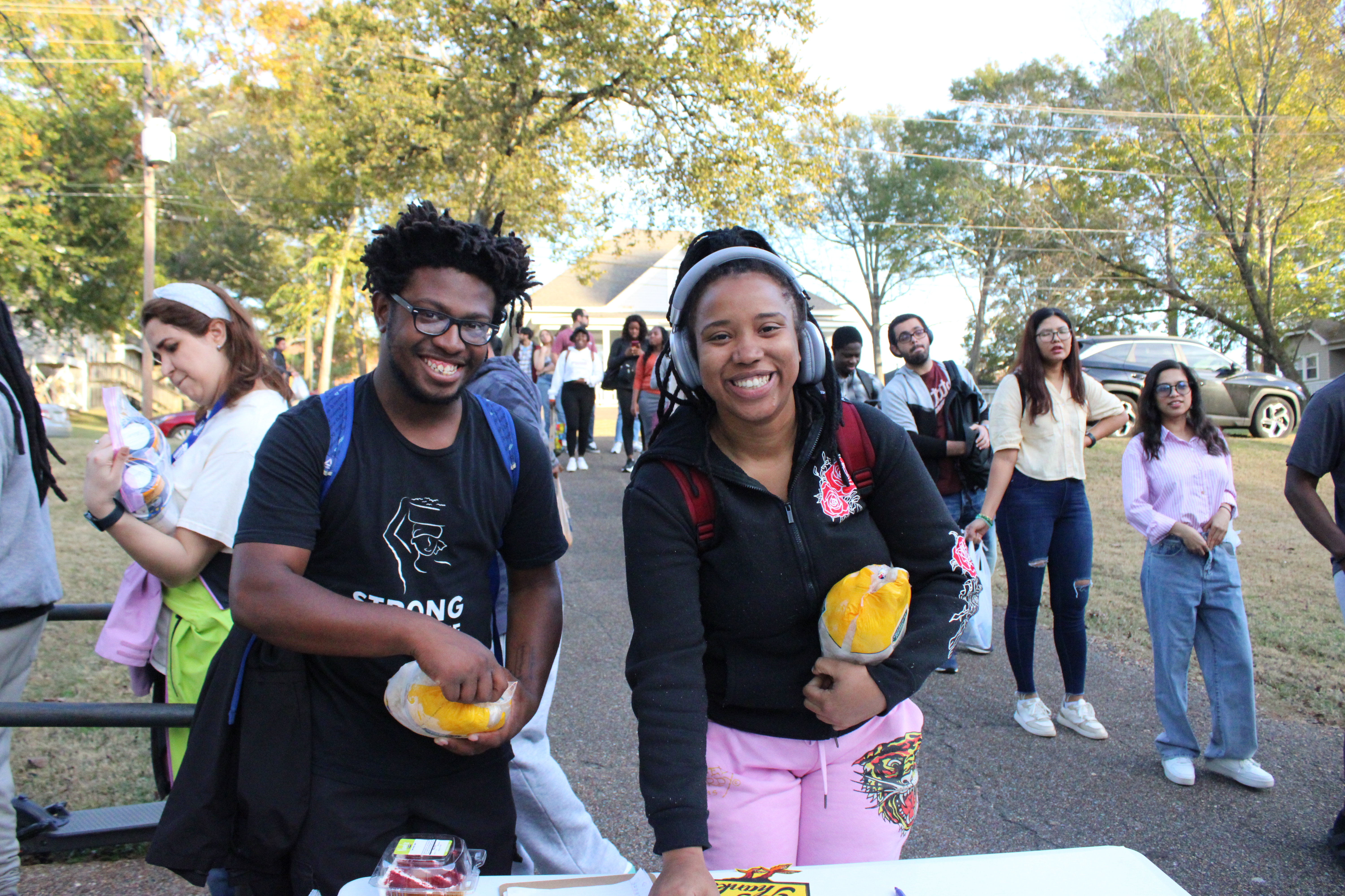 Photo of two students signing a card after receiving free chickens from Bully's Pantry